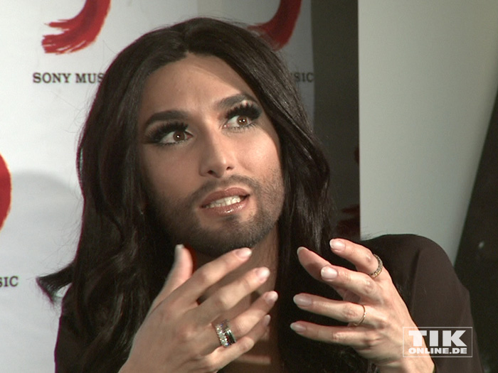 Conchita Wurst erklärt mit ausladenden Gesten ihr Leben